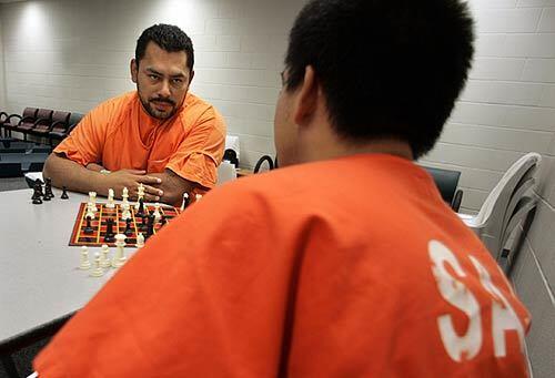 Tomas Castro Lopez, left, plays chess with a fellow El Salvadoran detainee in the transfer area for Immigration and Customs Enforcement agency detainees at the Santa Ana Jail.