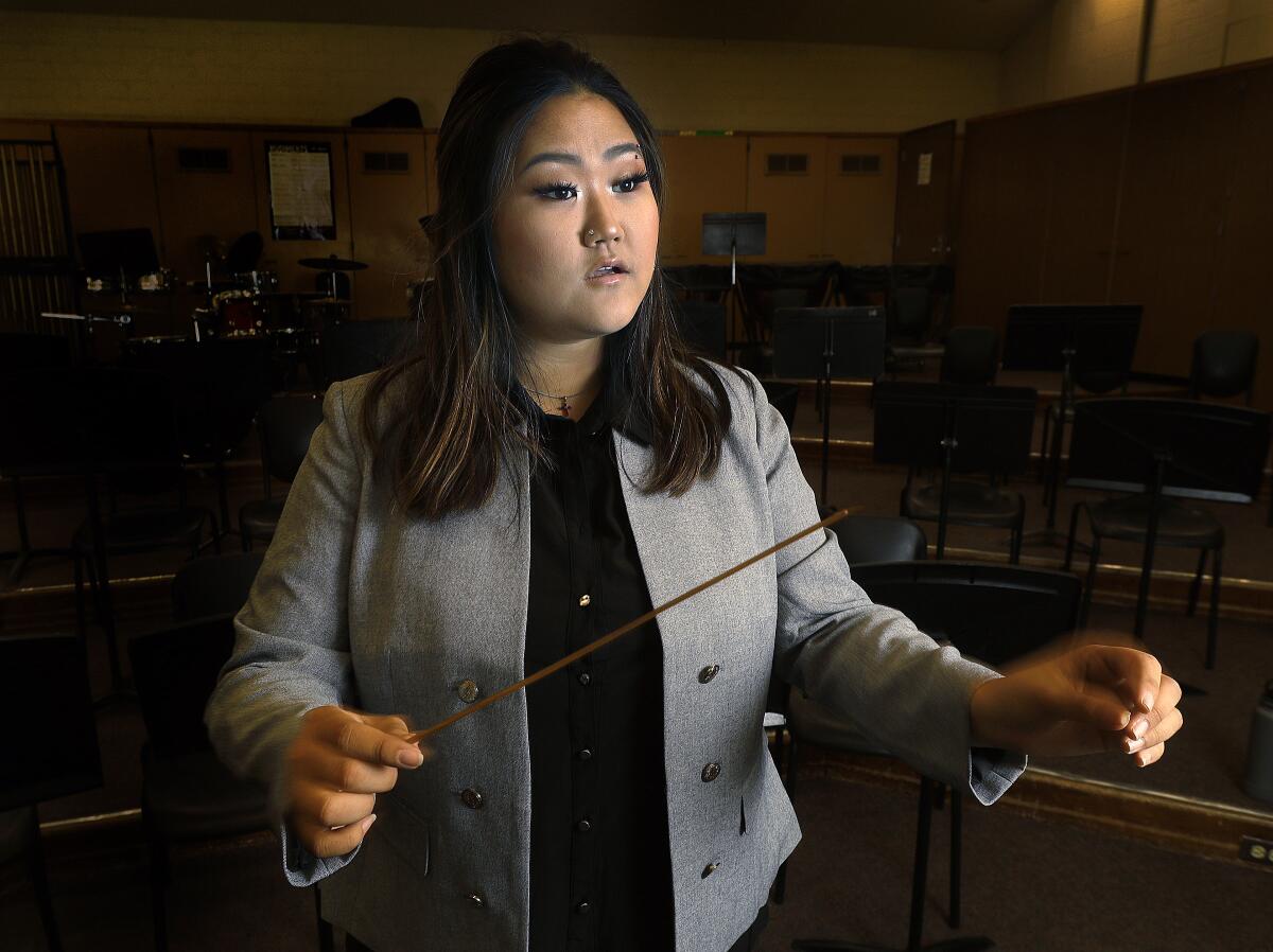 Glendale High School senior Elizabeth Kim in the large music room at Glendale High School on Wednesday. Kim was one of three local students selected to the Discovery Conductors mentorship program through the Burbank Philharmonic. Kim will take part in master classes and will guest conduct for the philharmonic on Saturday's opening night.