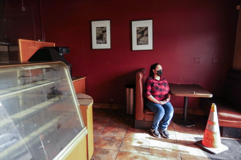 Stephanie Ramirez sits in a booth inside her fire damaged bakery Spigas Bakery