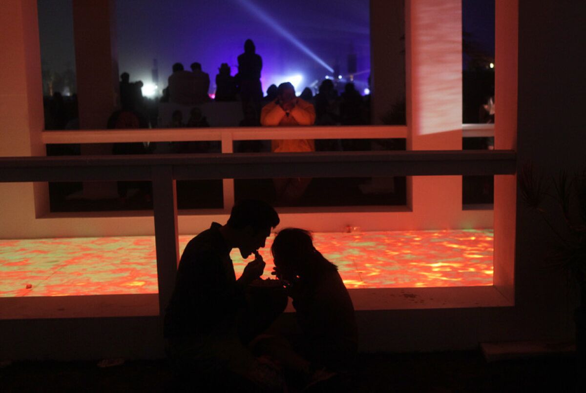A couple enjoy a quiet meal at the Mirage, an art installation on the grounds of Coachella.