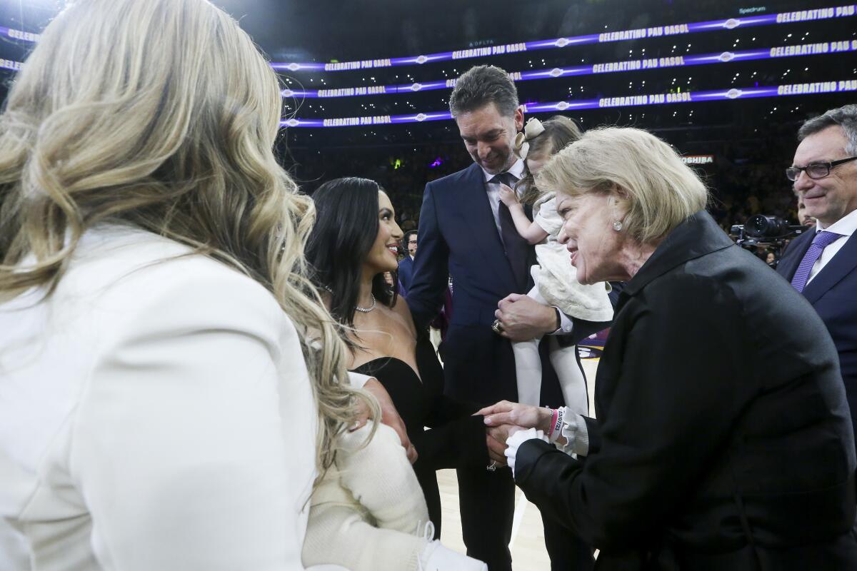Pau Gasol, center, holds his daughter Elisabet Gianna while speaking with Vanessa Bryant, godmother to his daughter.