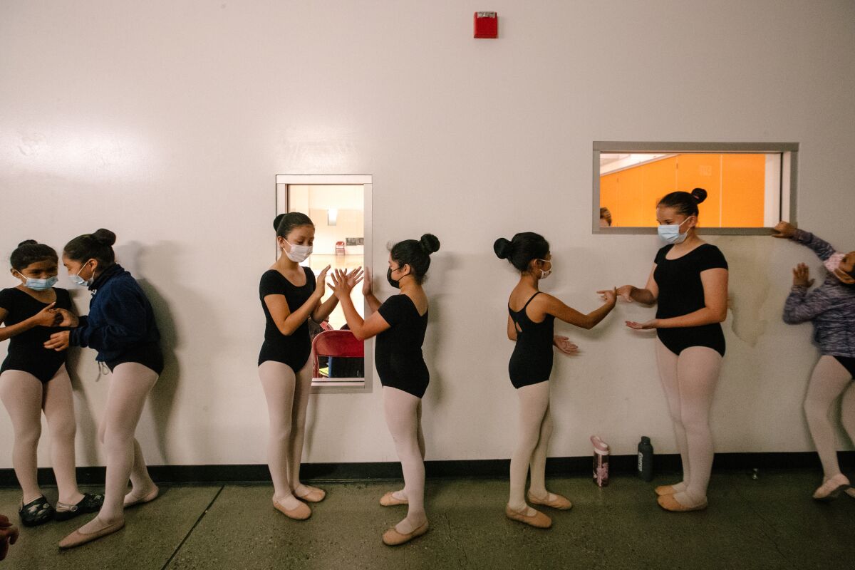 Girls in ballet outfits play handgames 