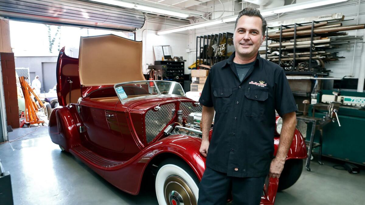 Hollywood Hot Rods owner Troy Ladd stands next to a custom-made 1936 Packard at his shop in Burbank on Thursday. The vehicle, hand-built from the ground up, boasts a Lincoln V-12 engine and a manual 5-speed transmission.