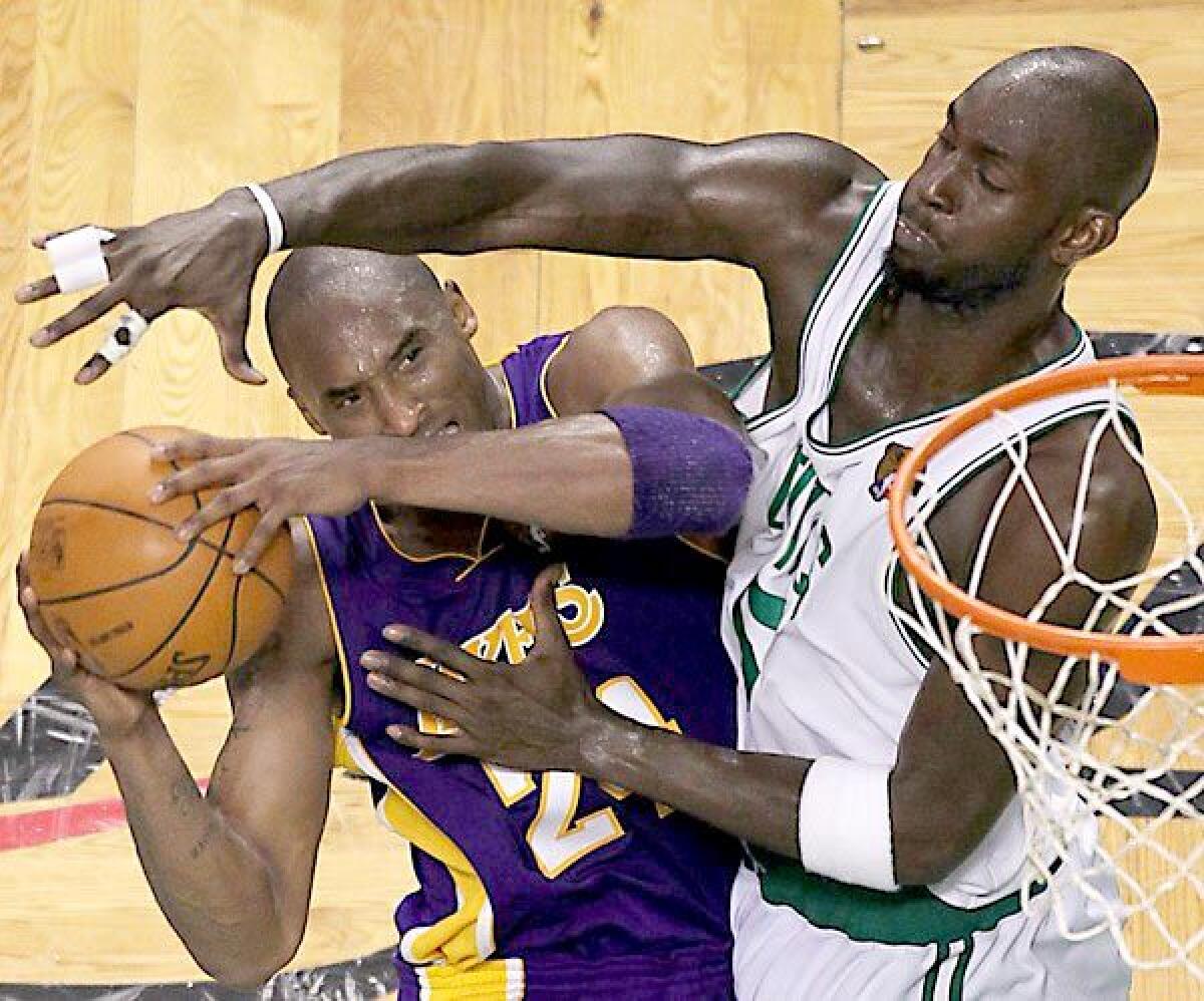 Celtics forward Kevin Garnett forces Lakers guard Kobe Bryant into a difficult shot.