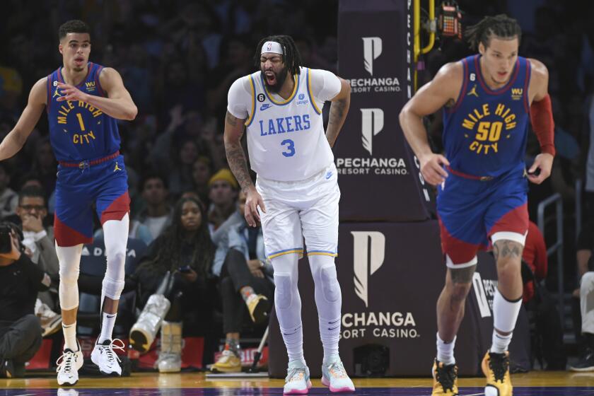 Los Angeles Lakers forward Anthony Davis (3) winces after injuring his back in the second half of an NBA basketball game against the Denver Nuggets Sunday, Oct. 30, 2022, in Los Angeles. The Lakers won 121-110. (AP Photo/Michael Owen Baker)