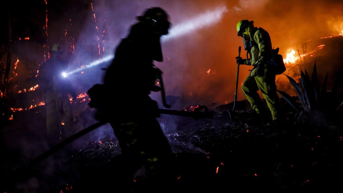 Firefighters work to control a brush fire in Ventura on Dec. 5, 2017.