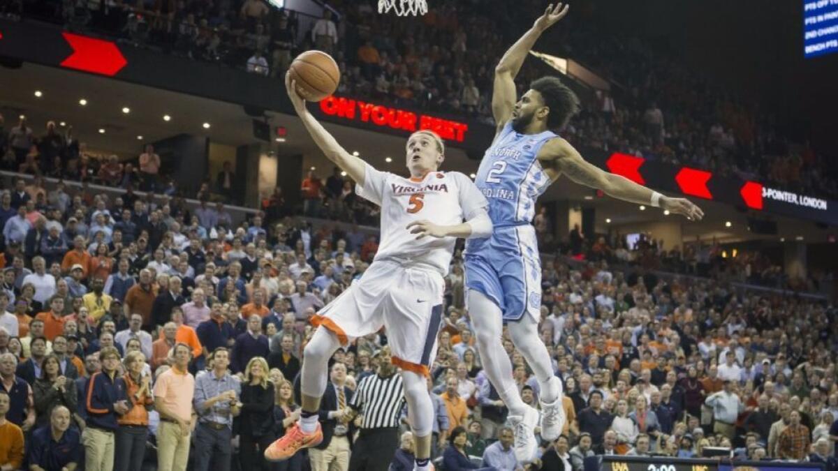 Virginia guard Kyle Guy (5) drives to the basket in front of North Carolina's Joel Berry II (2) in the second half on Feb. 27.
