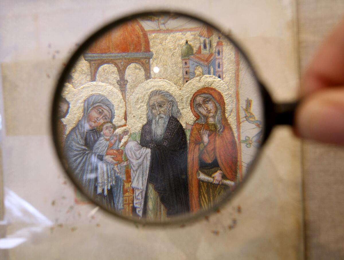 Miniature artwork by Aram Vartanov, seen through a magnifying glass, is being displayed at Roslin Art Gallery, 415 E. Broadway, in Glendale on Saturday, November 21, 2015.