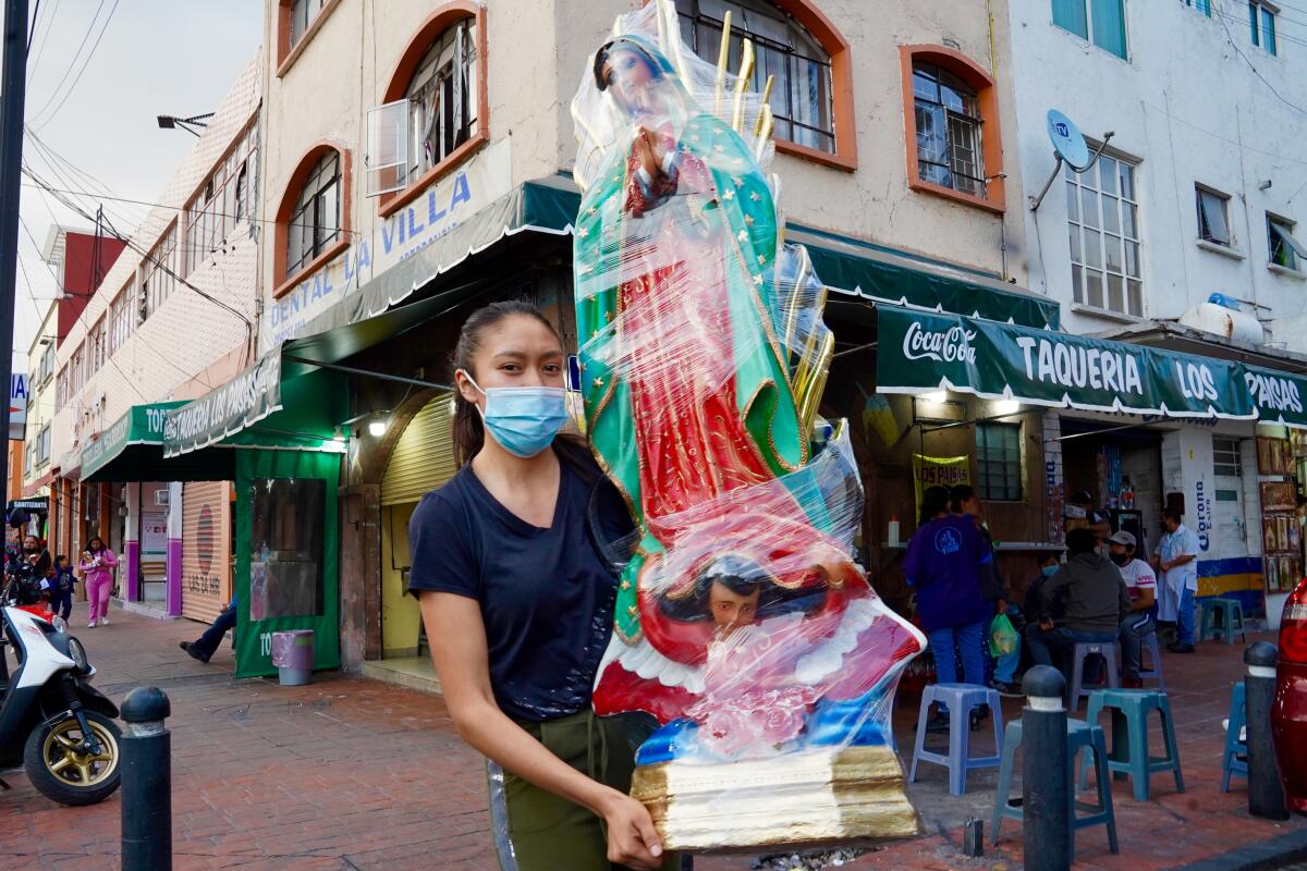 Brenda Ramirez Navarro, 23 carries a plaster figure of the Virgin of Guadalupe near the Basilica of Guadalupe.