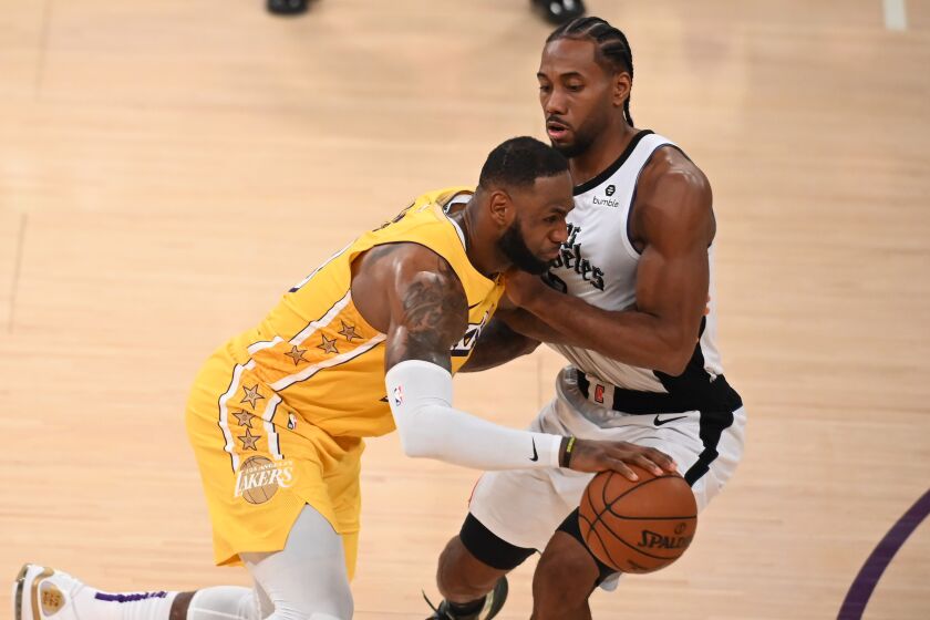 Los Angeles Lakers forward LeBron James (L) drives past Los Angeles Clippers forward Kawhi Leonard (R) during a Christmas Day National Basketball Association (NBA) match-up between the Los Angeles Clippers and Los Angeles Lakers at the Staples Center in Los Angeles, California on December 25, 2019. (Photo by Robyn Beck / AFP) (Photo by ROBYN BECK/AFP via Getty Images)