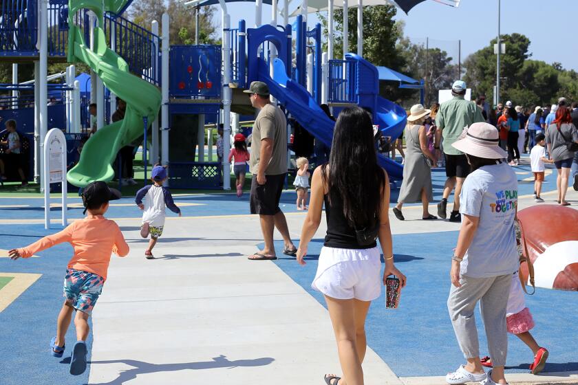 Families bring their children to play on the Fountain Valley Universally Accessible Playground during the Ribbon Cutting Ceremony at the Fountain Valley Sports Park in Fountain Valley on Friday, August 9, 2024. (Photo by James Carbone)