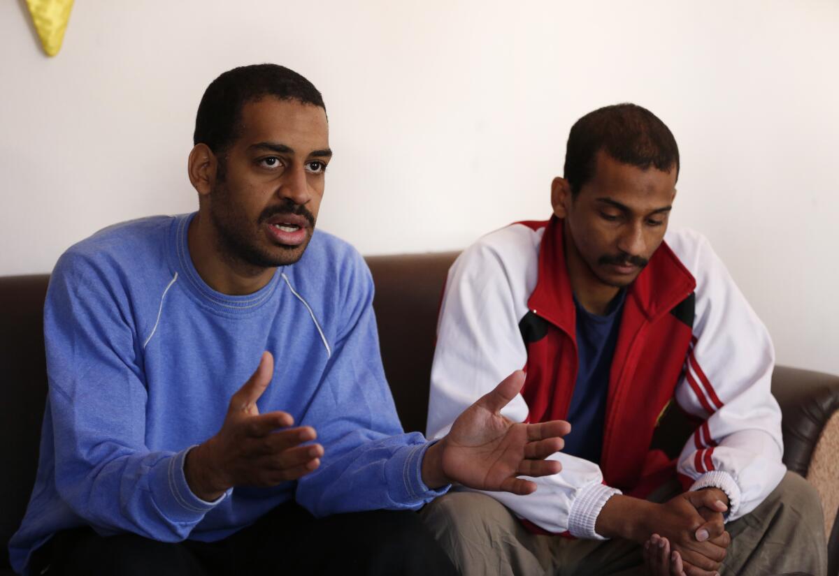 Alexanda Kotey, left, and El Shafee Elsheikh speak with reporters while seated on a couch in March 2019