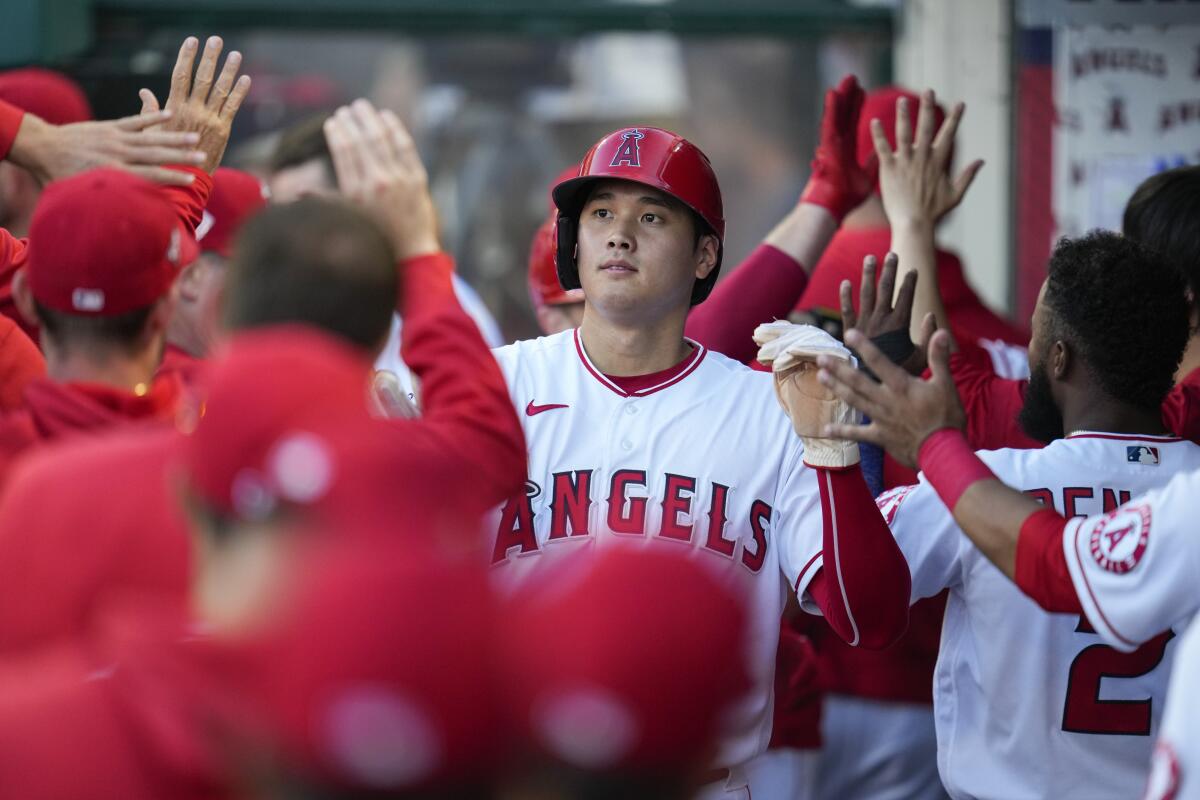 Los Angeles Angels' Shohei Ohtani (17) celebrates in the dugout after scoring 
