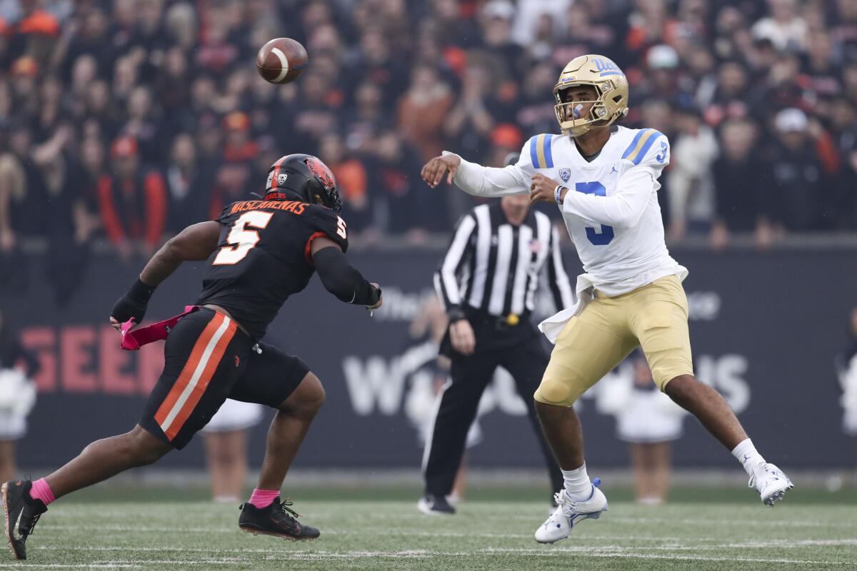 UCLA quarterback Dante Moore throws a pass in front of Oregon State linebacker Easton Mascarenas-Arnold.