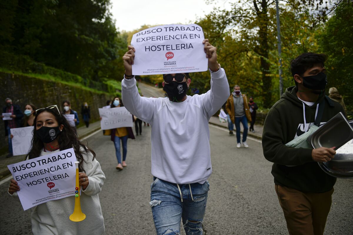 People hold up banners in support of the hotel industry in Pamplona, northern Spain.