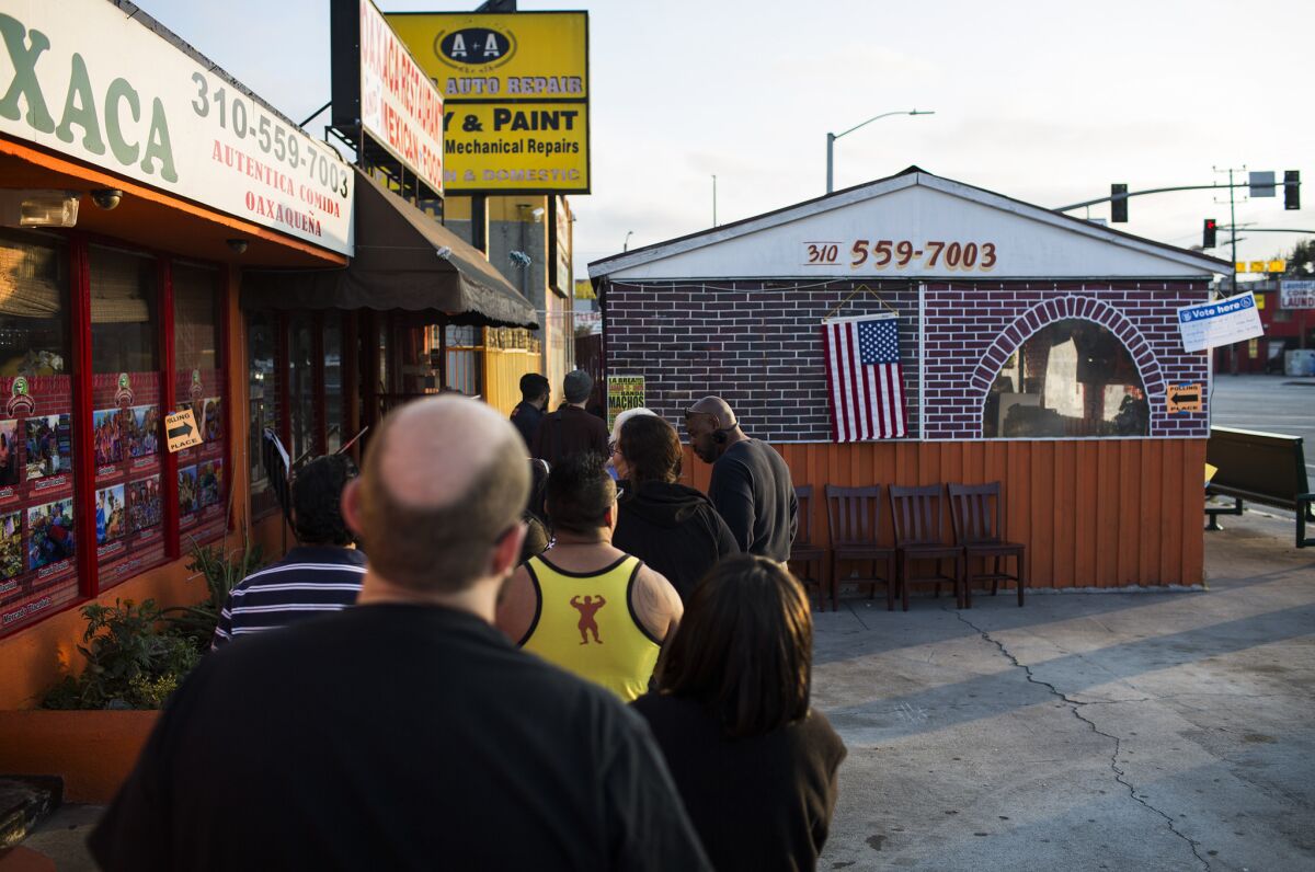 Voters wait in line at the Sabores De Oaxaca restaurant in Mid-City to cast their vote in California's June 7 primary.