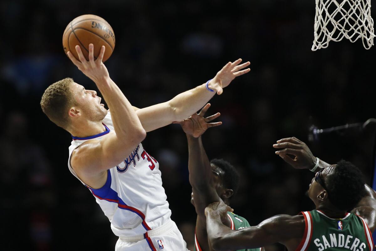 Blake Griffin, left, shoots as he is fouled by Milwaukee's Johnny O'Bryant III, center, while Larry Sanders also defends Saturday at Staples Center.