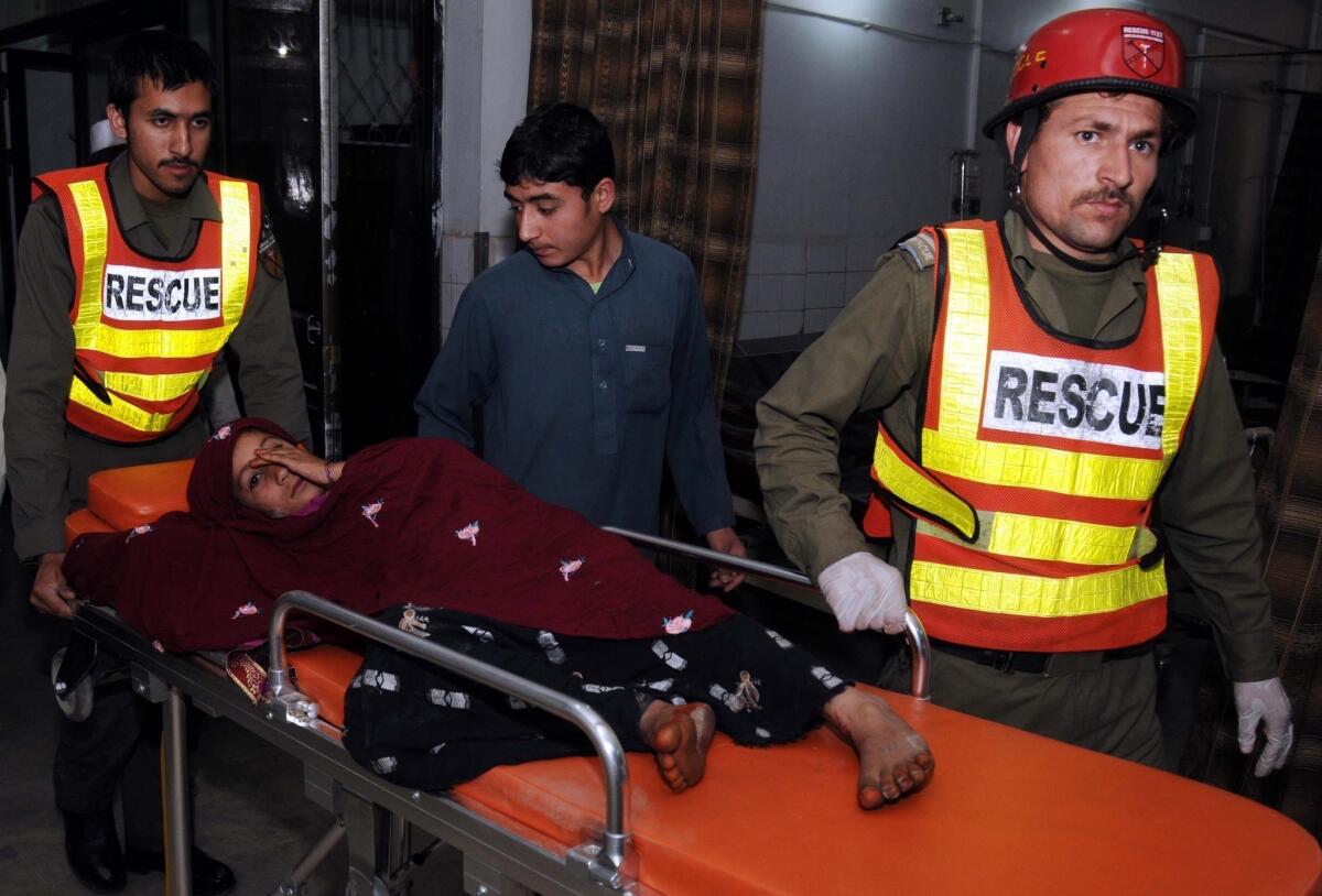 A girl injured in a bomb blast is taken to a hospital in Peshawar, Pakistan. The attack targeted the campaign office of an independent candidate in Charsadda.