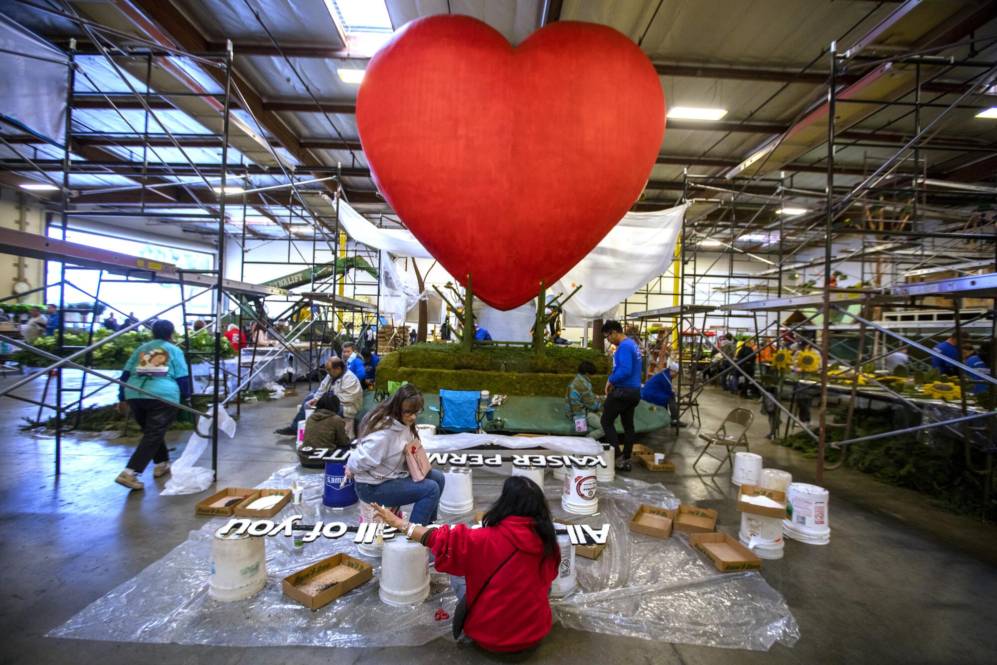 An enormous red floral-covered heart gets its finishing touches 