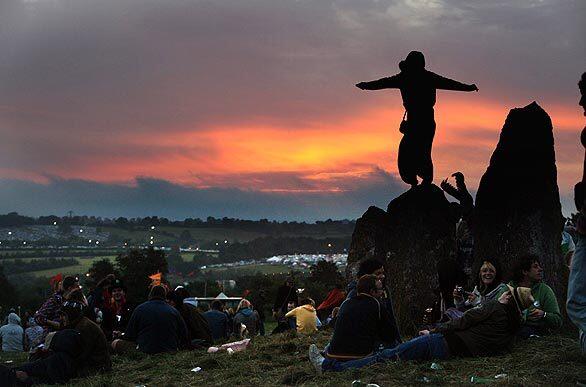 Some of the estimated 140,000 music fans expected at England's Glastonbury Festival welcome the dawn. The festival, held at Glastonbury's Worthy Farm, is one of Europe's largest music fests.