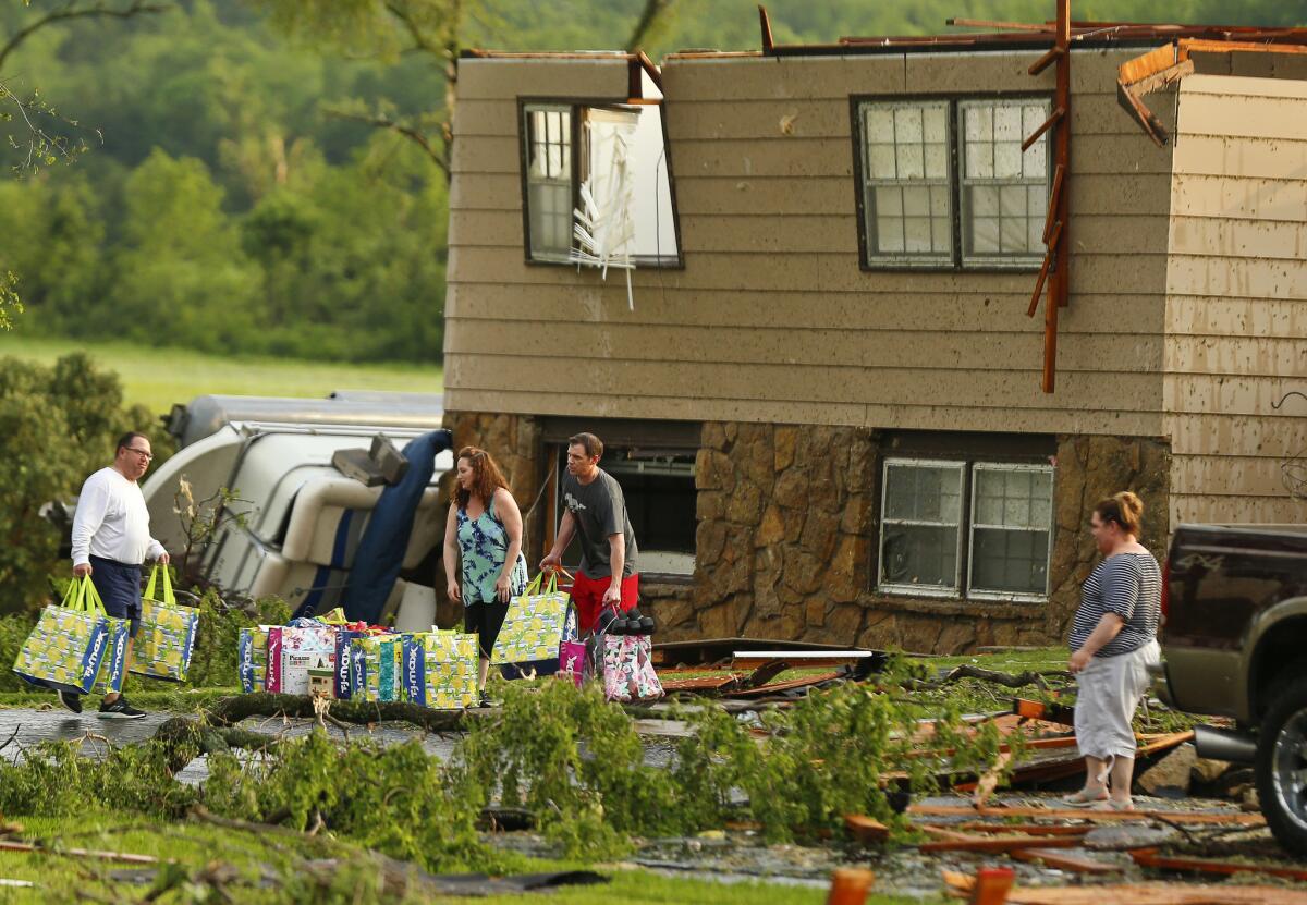 Family members gather their belongings after a tornado hit their home in a neighborhood south of Lawrence, Kan.