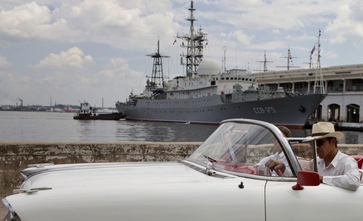 An American classic car passes in front of the Russian warship, The Viktor Leonov CCB-175, docked in Havana's harbor in Havana, Cuba. Despite the absence of official diplomatic relations, Cuba remains a major component of U.S. foreign policy.