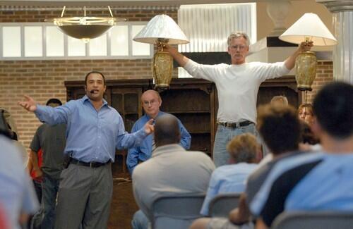 Hamid Parvizian, left, leads the auction as Niall Anderson holds up items available at the store's liquidation sale.