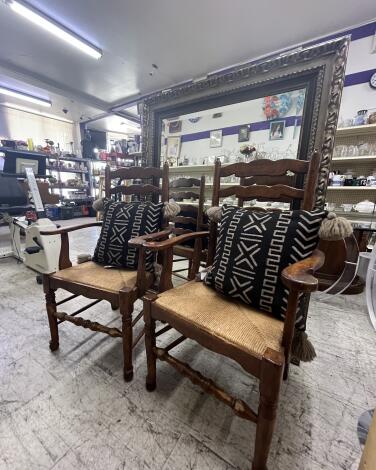 Two chairs with throw pillows, a mirror and household goods at a thrift shop
