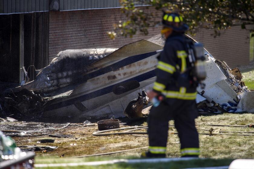 A firefighter near the wreckage of an aircraft that crashed into a building in Farmington, Conn.,. Sept. 2, 2021. The small jet that crashed, killing four people earlier this month, was going slower than usual as it took off from an airport runway, while witnesses saw a puff of smoke and noticed the aircraft was having trouble gaining altitude, according to a preliminary investigation report released Tuesday, Sept. 26 2023. (Mark Mirko/Hartford Courant via AP, file)