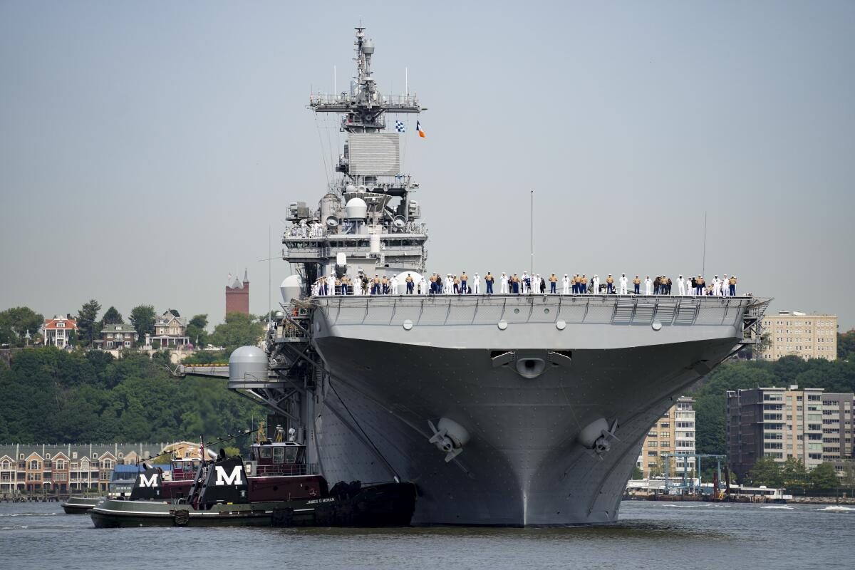 People stand on the USS Wasp amphibious assault ship on the Hudson River