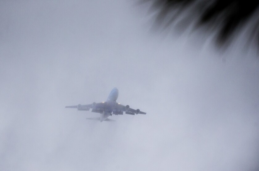 An Air Force plane carrying former President Obama and his family attempts to land at Palm Springs International Airport, but the aircraft was diverted to Riverside County because of severe wind and rain.