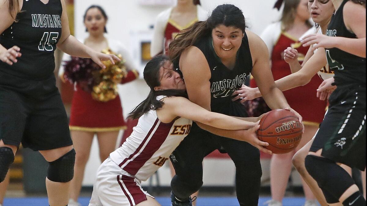 Costa Mesa High's Katie Belmontes, right, is fouled in the first half of the Battle for the Bell rivalry game against Estancia on Feb. 7, 2018.