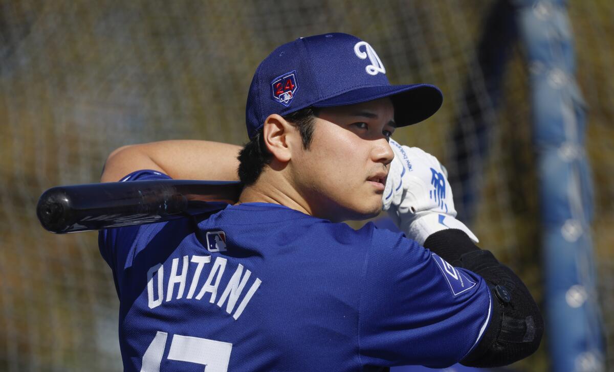 Dodgers' Shohei Ohtani warms up near the batting cage before taking some swings during spring training on Feb. 14, 2024.