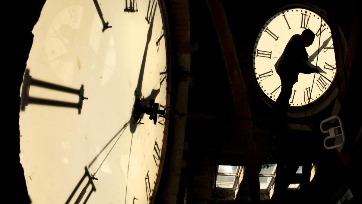 A custodian changes the time on a clock face atop the courthouse in Clay Center, Kan. on Nov. 6, 2010.