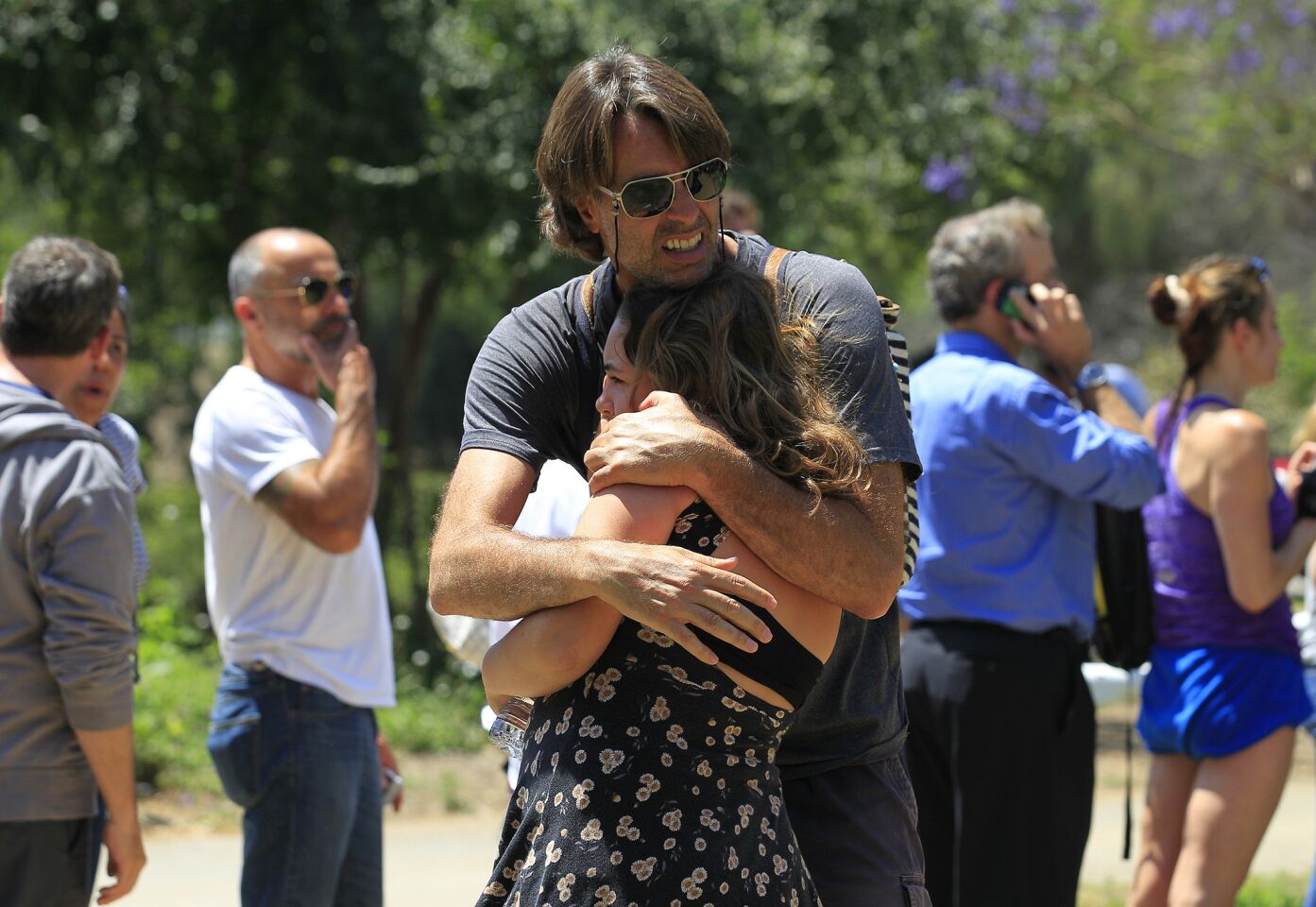 A man hugs his daughter after she was evacuated from Oakwood School in North Hollywood.