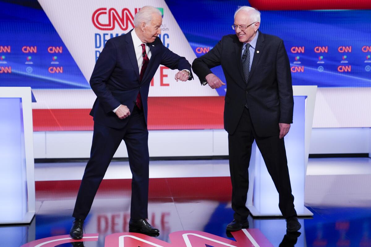 Former Vice President Joe Biden, left, and Vermont Sen. Bernie Sanders greet each other before they participate in a Democratic presidential primary debate Sunday at CNN studios in Washington.