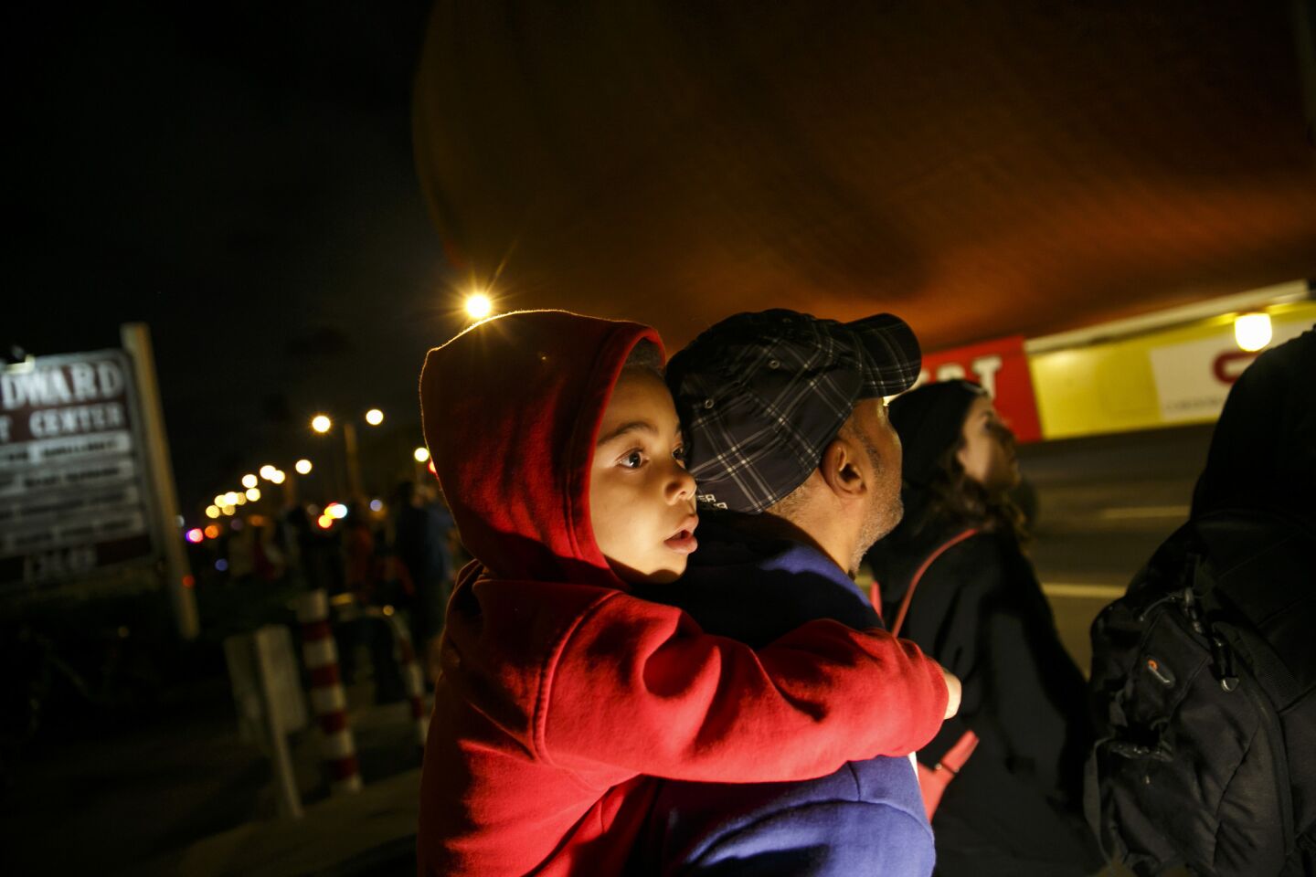 Freddy Tyson and his son Nicholas, 5, watch as the shuttle fuel tank makes its way toward Exposition Park.