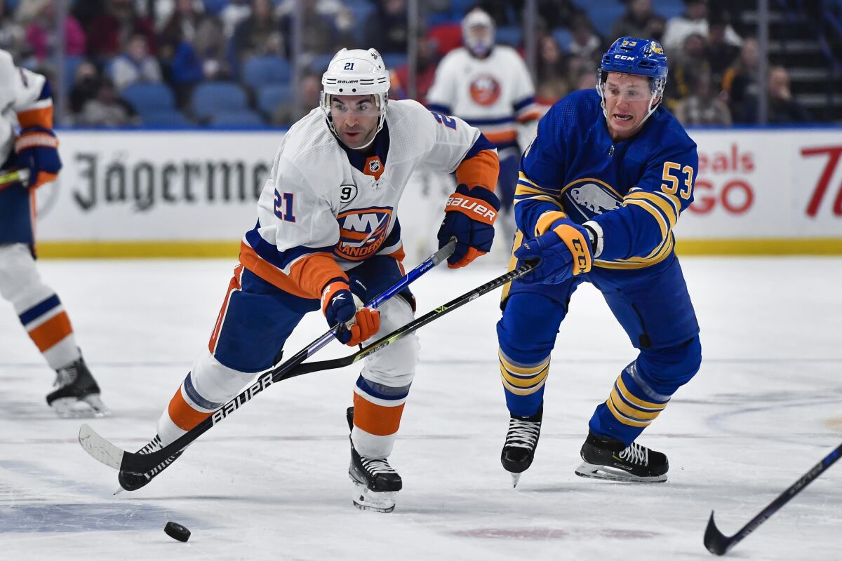 New York Islanders right wing Kyle Palmieri, left, and Buffalo Sabres left wing Jeff Skinner chase the puck during the first period of an NHL hockey game in Buffalo, N.Y., Tuesday, Feb. 15, 2022. (AP Photo/Adrian Kraus)