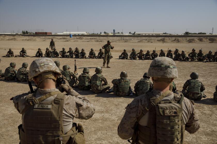 CAMP SHORAB, HELMAND PROVINCE -- MONDAY, OCTOBER 30, 2017: U.S. Marines Sgt. Matt Deitrich, left, and Sgt. Joseph O'Brien, right, of Alpha Company 1st Battalion 24th Regiment, overlooks the advance training for the solders of the 3rd Company 6th Battalion 215th ANA corp in Helmand Province, on Oct. 30, 2017. About 300 U.S. Marines are deployed in Helmand Province, in southern Afghanistan to train, advice and assist Afghan security forces who are battling the Taliban. The move puts Americans back in a combat role in Helmand province, where Marines fought for more than a decade before they were withdrawn in 2014.(Marcus Yam / Los Angeles Times)