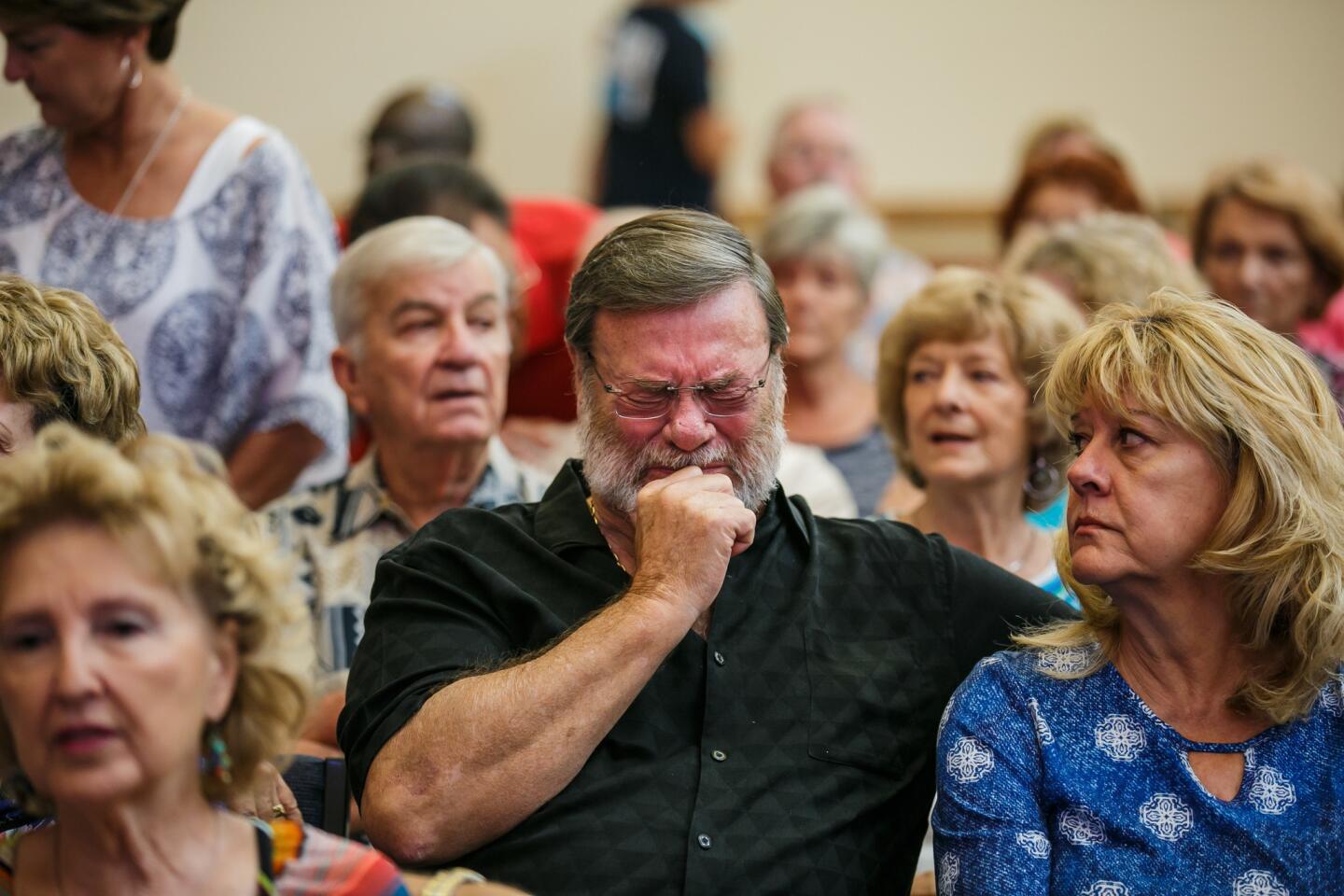 Wayne Christopher, center, weeps as his wife, Helen Christopher, looks on during the first Sunday service since Tropical Storm Harvey caused widespread flooding and damaged the First United Methodist Church.