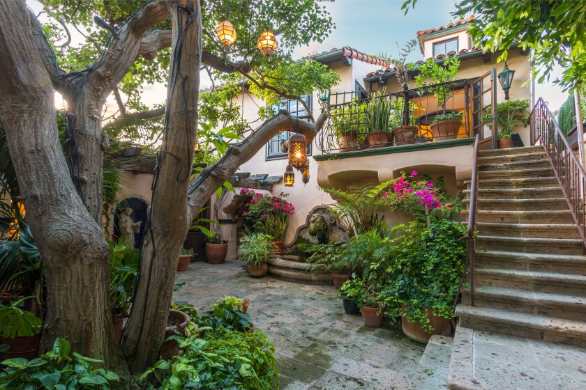 Built in 1927, the two-story home features Mediterranean style with rustic beams, stone floors, arched doorways and stained glass skylights.