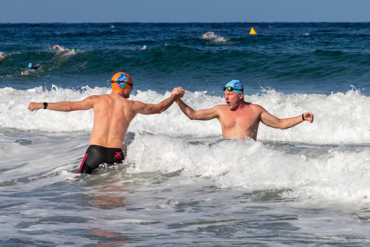 During the La Jolla Cove 10 Mile Relay, teammates hand off turns in the water after completing a 1-mile lap.