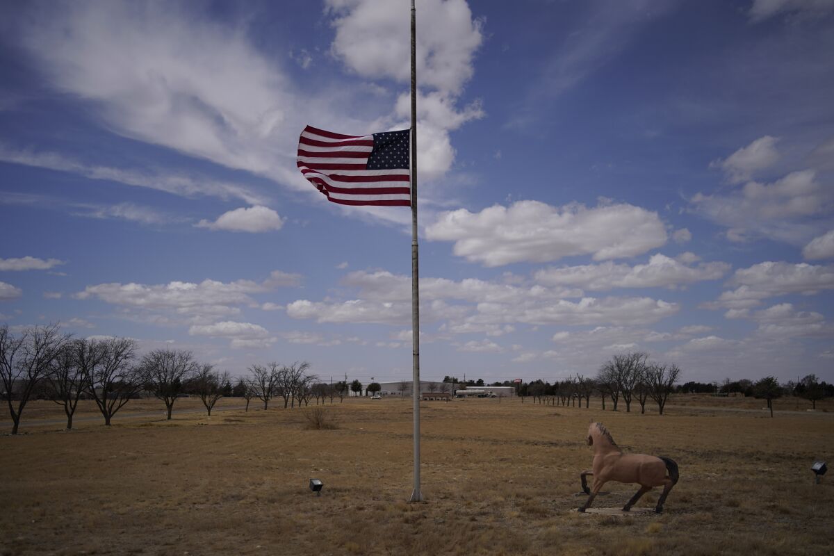 A flag flies at half staff at the University of the Southwest, Thursday, March 17, 2022, in Hobbs, N.M. Several student golfers and the coach of University of the Southwest were killed in a crash in Texas. (AP Photo/John Locher)