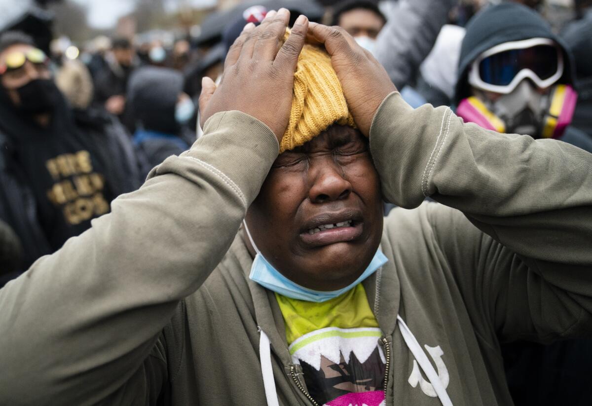 A demonstrator reacts during a standoff with police along a perimeter fence during a protest decrying the shooting death of Daunte Wright, outside the Brooklyn Center Police Department, Wednesday, April 14, 2021, in Brooklyn Center, Minn. (AP Photo/John Minchillo)