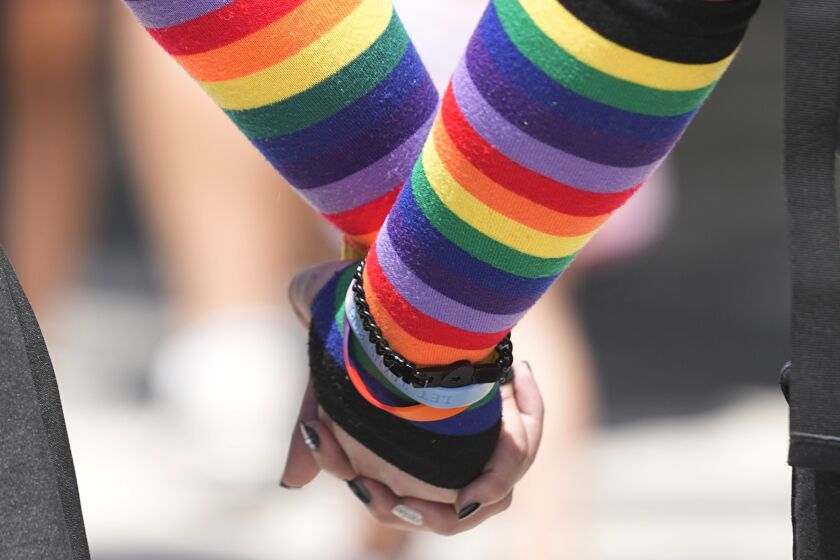 A couple hold hands at they leave the Pride Parade, Saturday, June 10, 2023, in Indianapolis. (AP Photo/Darron Cummings)