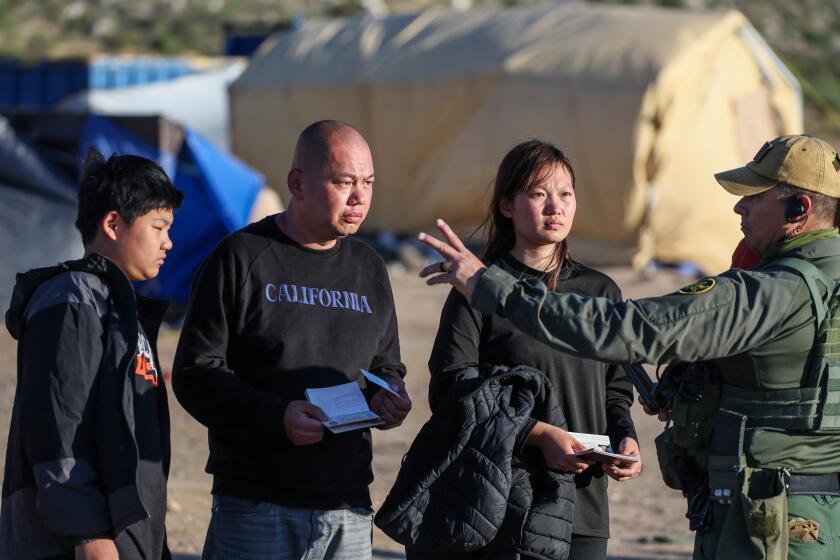 Jacumba Hot Springs, CA, Sunday, May 12, 2024 - Chinese migrant Zhen Jiang and his family receive direction from a Border Patrol agent hours after crossing the border through rocky, mountainous terrain. (Robert Gauthier/Los Angeles Times)