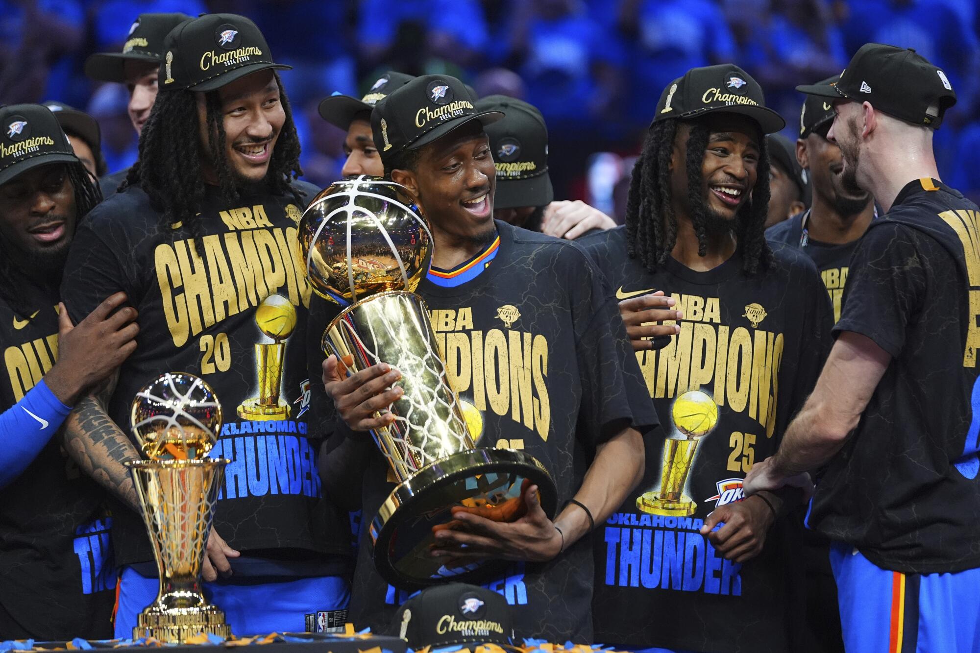 Oklahoma City forward Jalen Williams holds the Larry O'Brien Trophy as the Thunder celebrate their NBA championship.