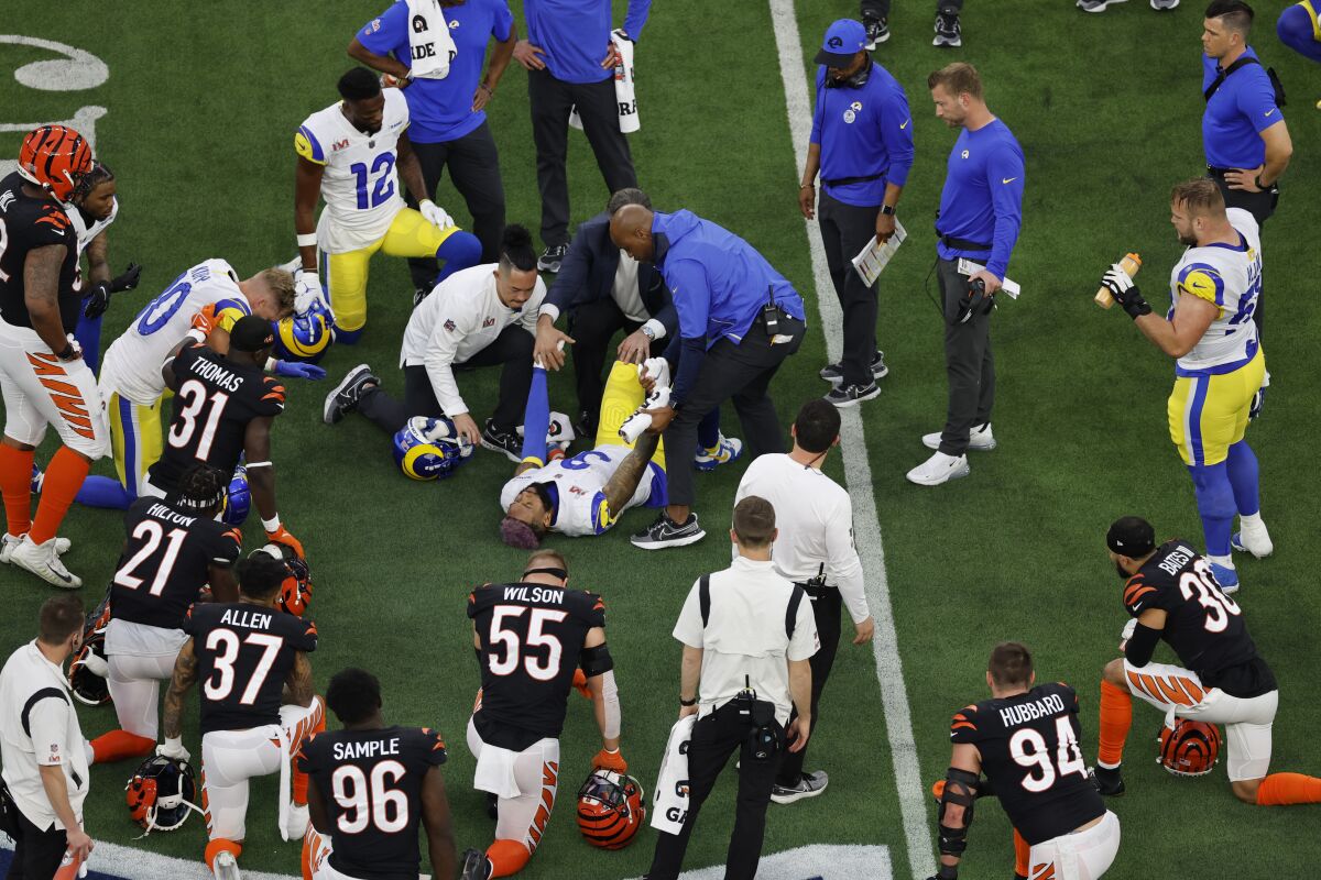 Rams and Bengals players kneel as Rams wide receiver Odell Beckham Jr. is attended to by trainers.