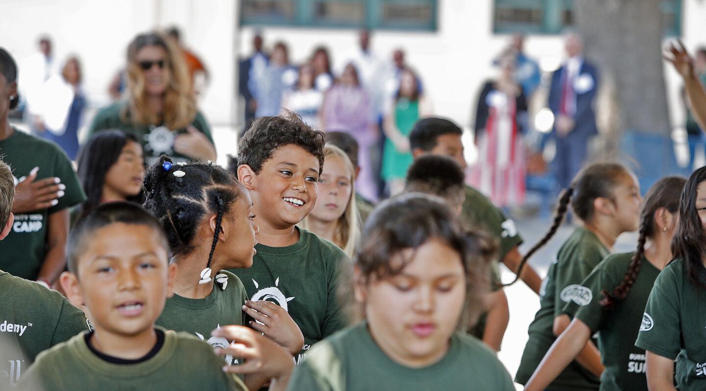 Students happily perform for the tour group listening in the background at a tour of the Learn, Grow, Thrive summer school program by the Burbank YMCA at Emerson Elementary School in Burbank on Thursday, July 12, 2018. The six-week program is a full-day academic program with a goal of enriching elementary education to make sure young students enter their next grade prepared.