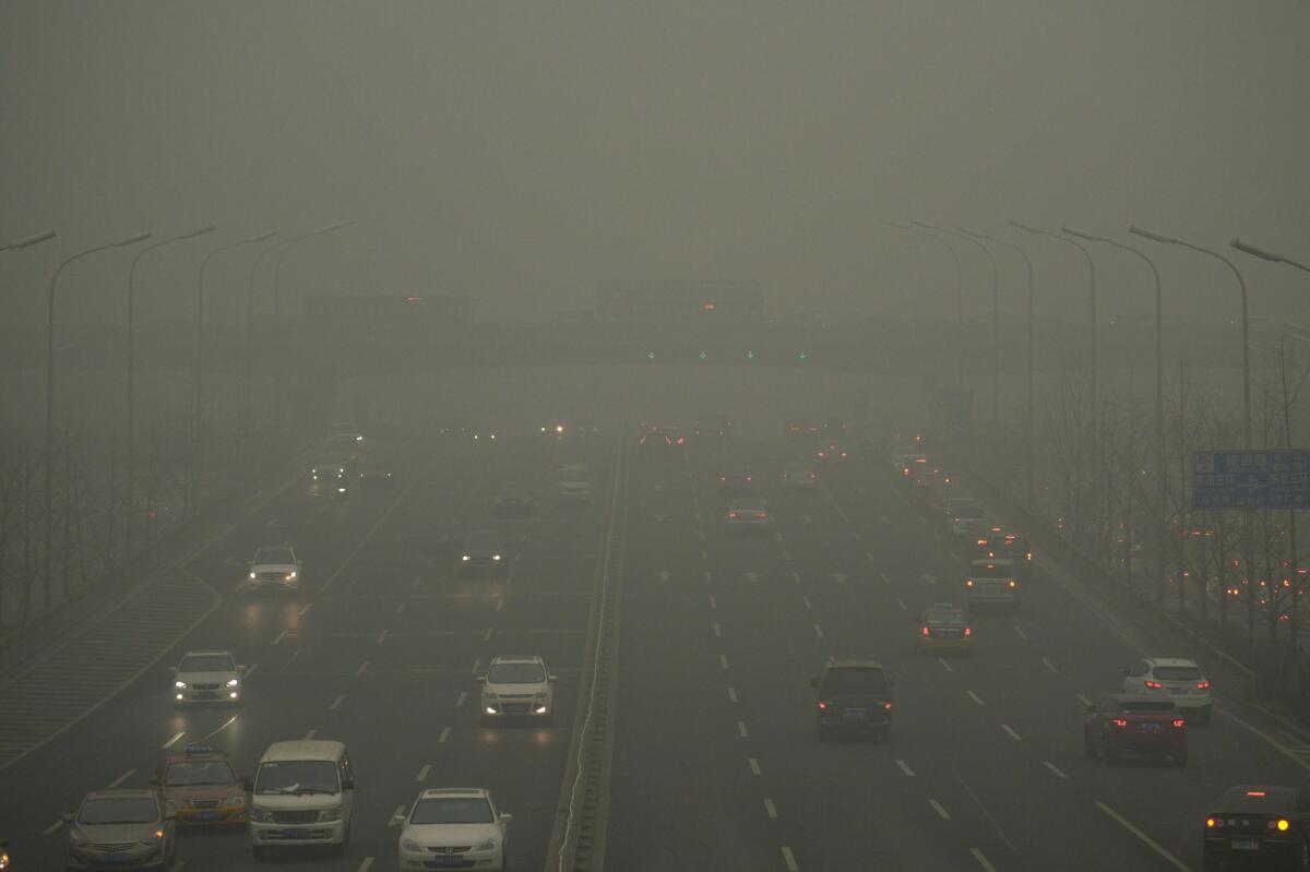 Cars disappear into smog in Beijing on Tuesday.